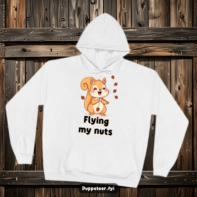 Funny Squirrel Hoodie depicting a cheerful squirrel making acorns fly through the air with strings, ideal for cozy, playful moments.