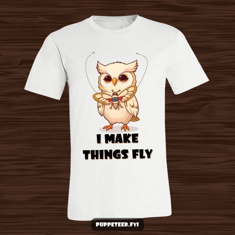 Funny t-shirt featuring a whimsical owl character using delicate strings to make a moth puppet fly, creating a magical scene.