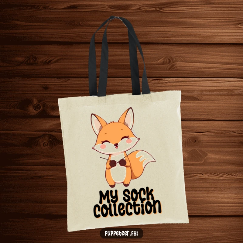 Funny tote bag showing a happy fox character making a sock puppet wave using crossed strings, a whimsical carry-all.